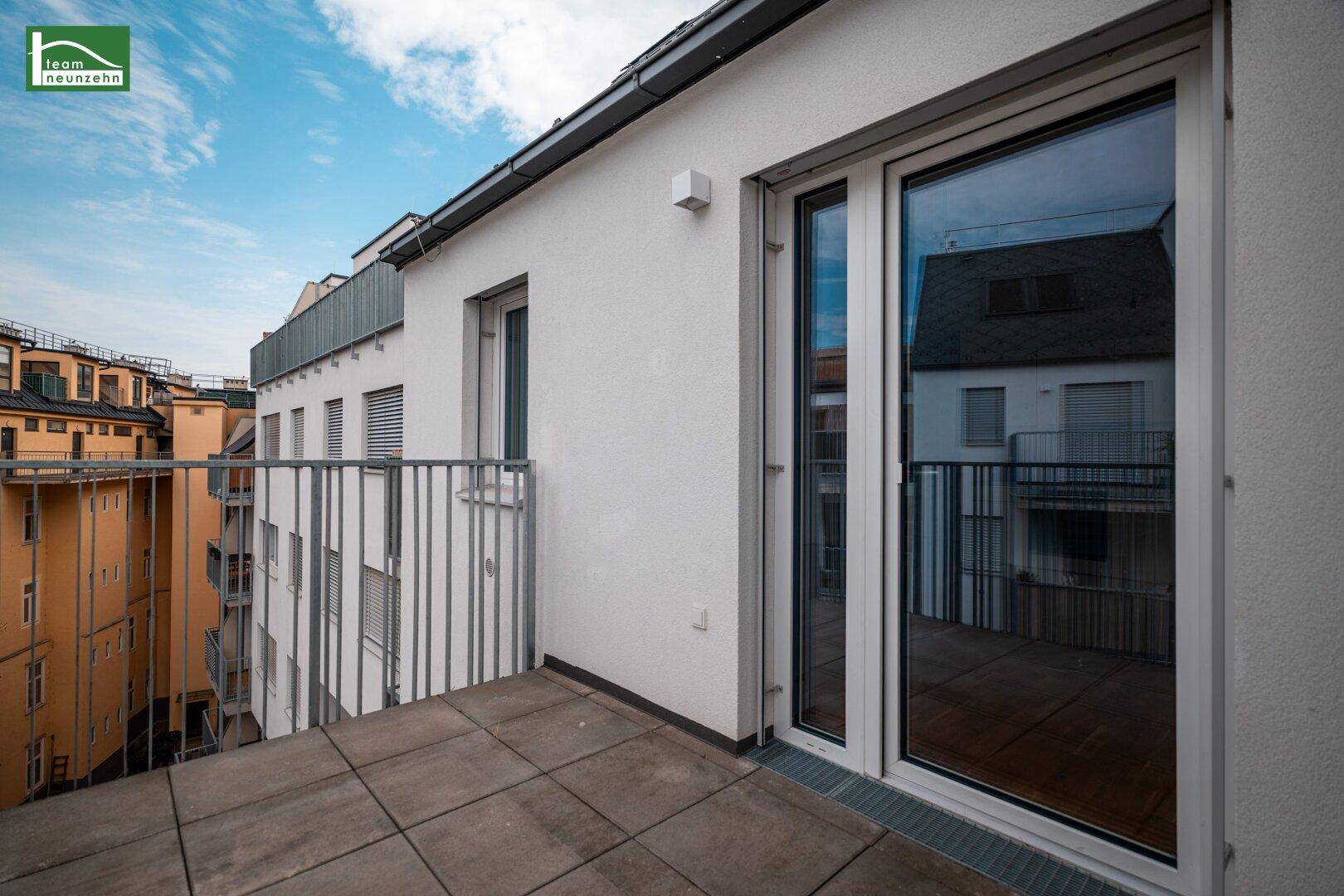 Geräumiger Balkon mit Fliesenboden und Zugang zum Innenbereich der Wohnung.