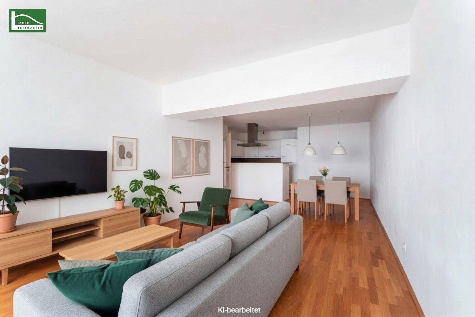 Offener Wohn-Essbereich mit Holzboden, moderner Einrichtung und einer integrierten Küche im Hintergrund.