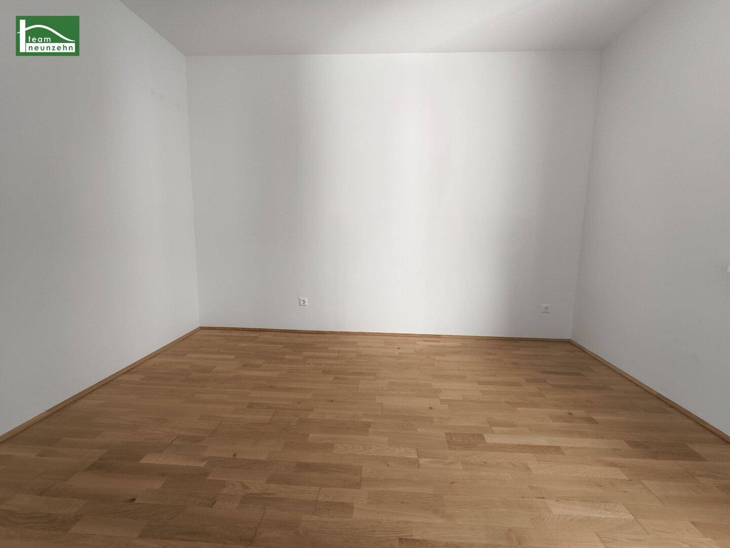 Ruhiges Schlafzimmer mit Parkettboden und weißen Wänden, bereit zur individuellen Gestaltung.