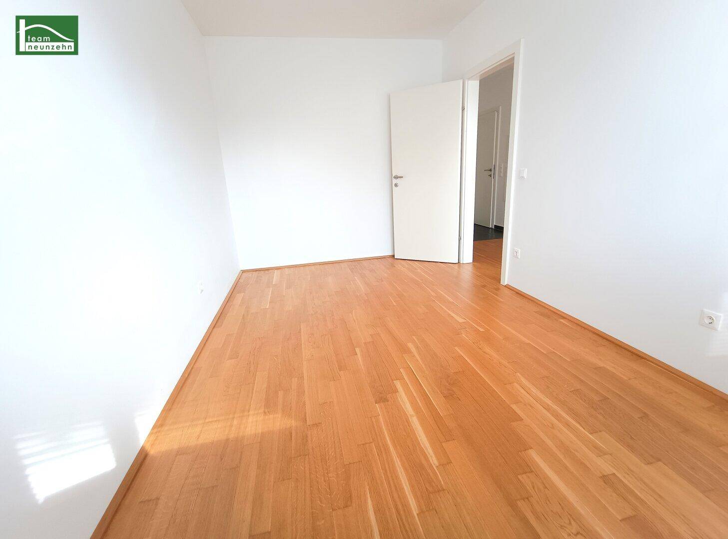 Leeres Zimmer mit hellem Parkettboden und weißen Wänden, bereit zur individuellen Gestaltung.
