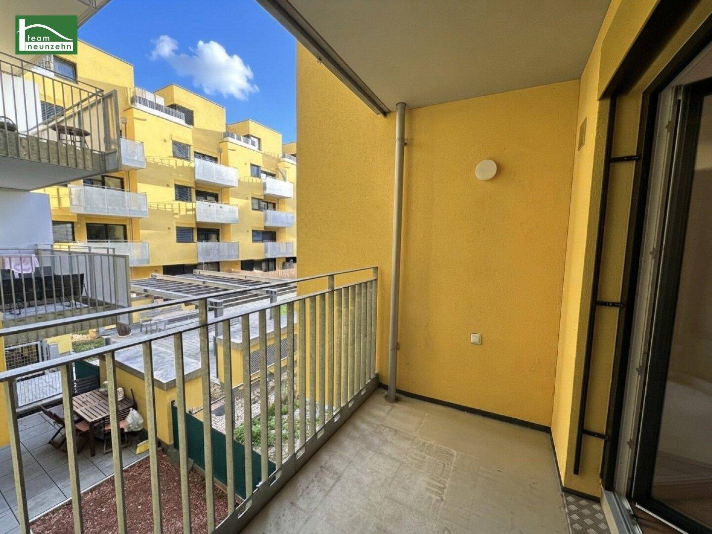 Balkon mit Blick auf den Innenhof und die umliegenden modernen Gebäude.