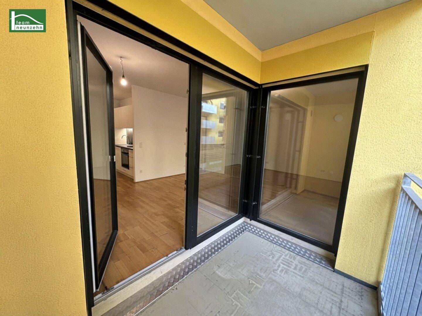 Geräumiger Balkon mit großen Glasfronten, die den Blick in den Wohnbereich freigeben.