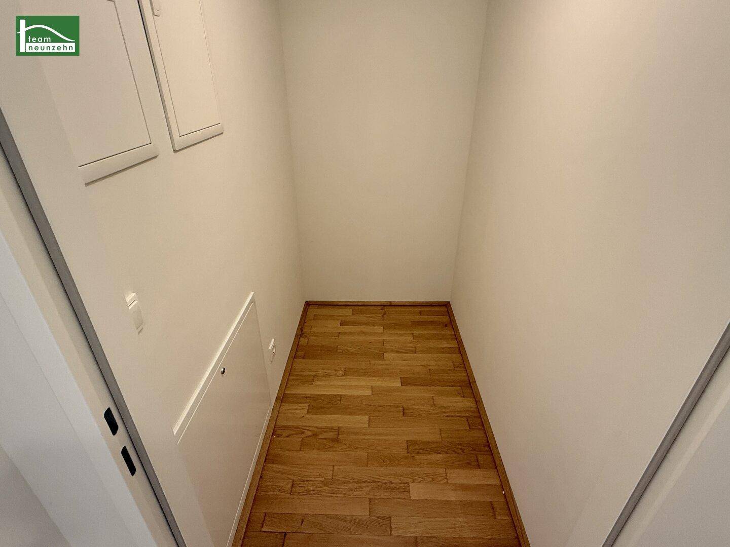 Praktischer Abstellraum mit Holzboden und weißen Wänden für zusätzlichen Stauraum.