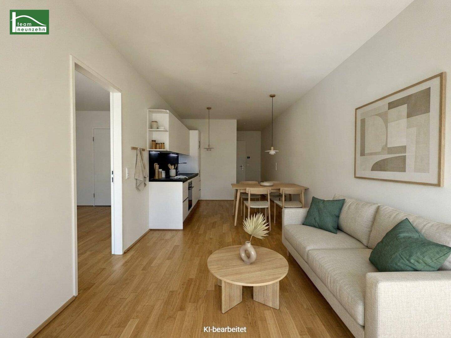Modern eingerichteter Wohn-Essbereich mit offener Küche und gemütlichem Sofa.
