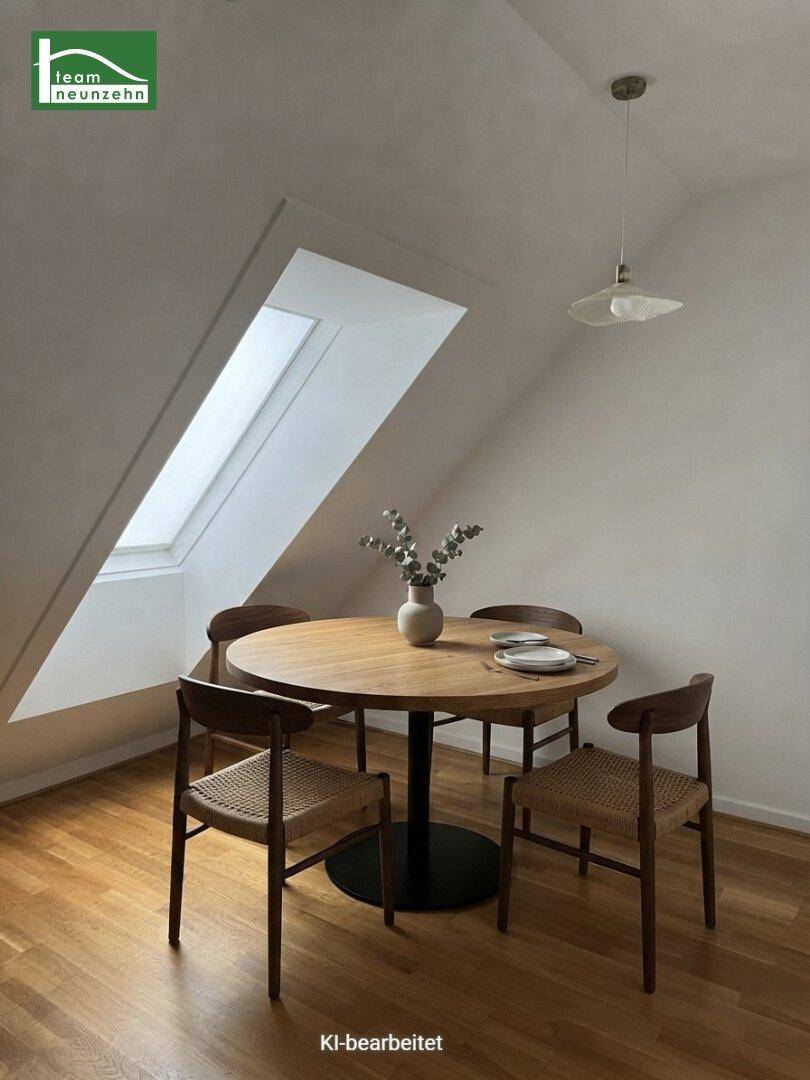 Heller Essbereich mit einem runden Holztisch, Stühlen und einem Dachfenster unter einer Dachschräge.