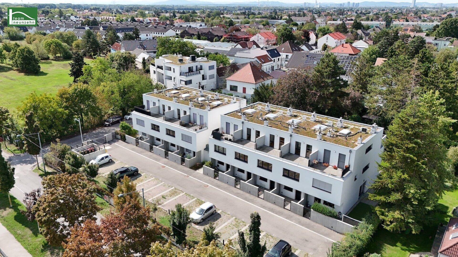 Übersicht der modernen Wohngebäude mit Flachdächern und Balkonen in einer grünen Wohngegend.
