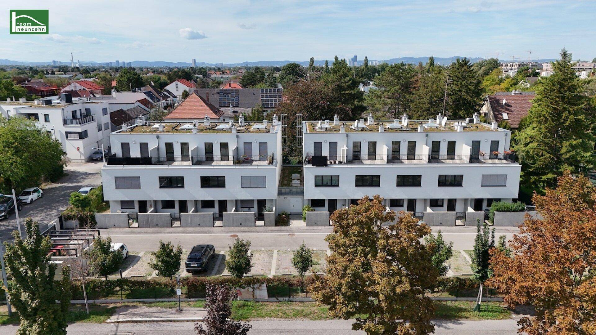 Vorderansicht der modernen Wohngebäude mit Balkonen, großen Fenstern und Parkmöglichkeiten.