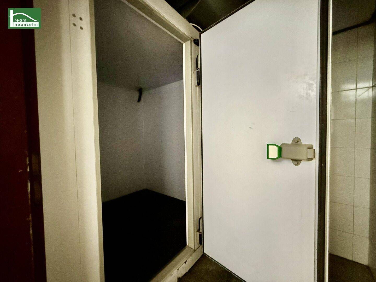 Begehbarer Kühlraum mit isolierter Tür, bereit für die Lagerung von Lebensmitteln oder Getränken.
