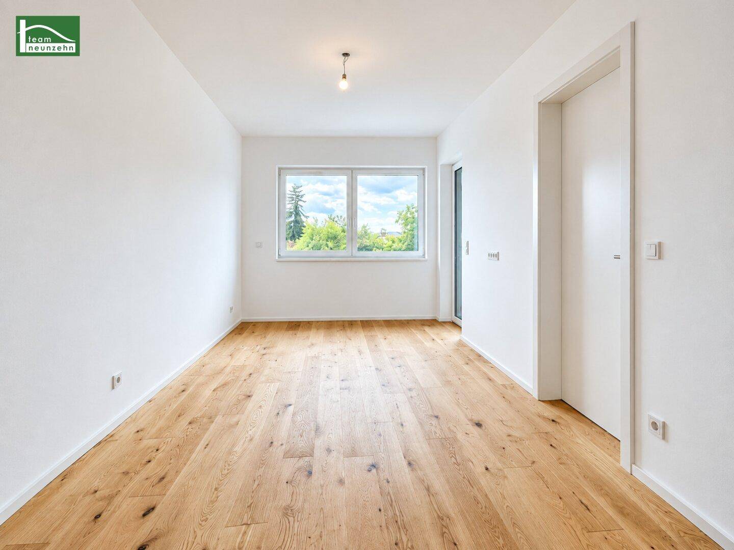 Helles, unmöbliertes Zimmer mit Parkettboden und großen Fenstern, ideal als Büro oder Gästezimmer.