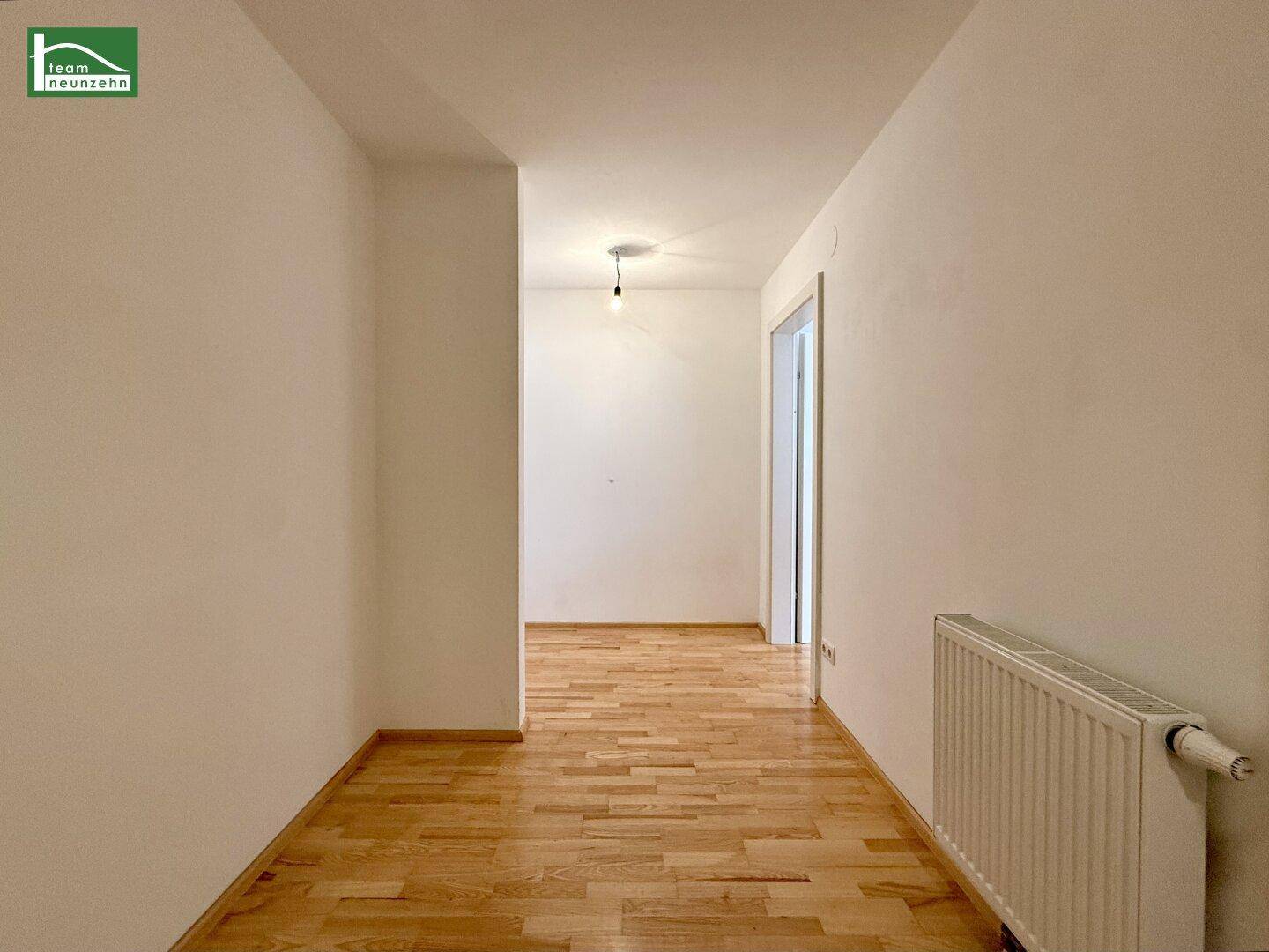 Heller Flur mit Parkettboden und Zugang zu weiteren Räumen der Wohnung.