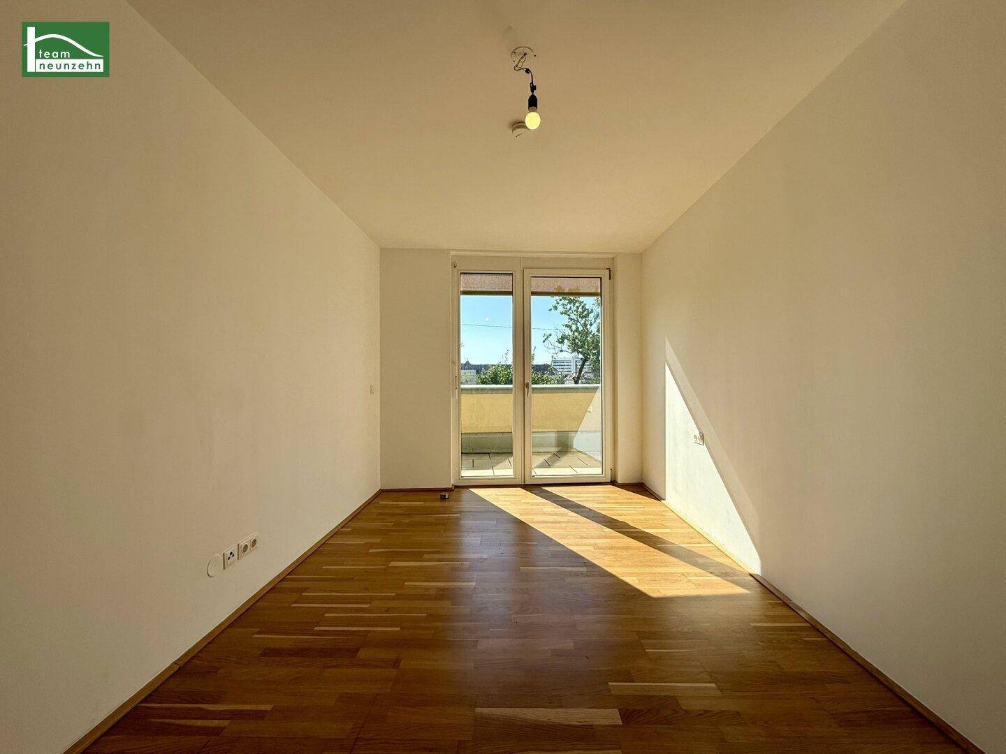 Lichtdurchflutetes Zimmer mit Parkettboden und direktem Zugang zum Außenbereich.