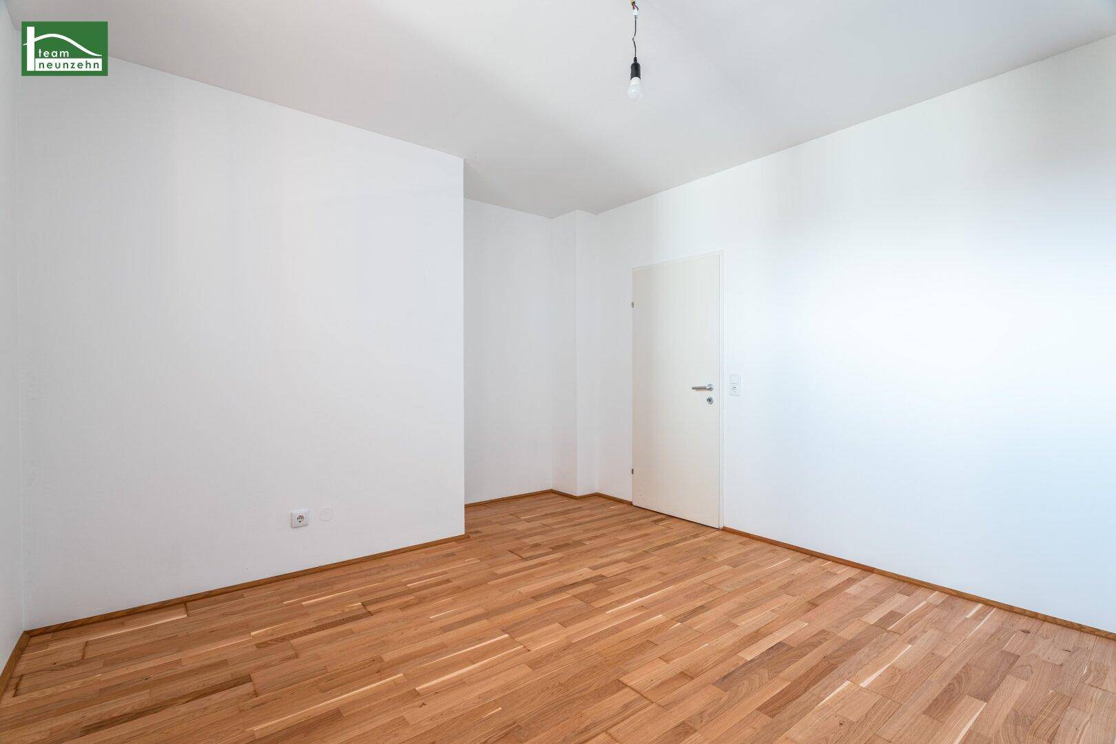 Leerer Raum mit Holzboden und weiß gestrichenen Wänden, ideal als Schlaf- oder Arbeitszimmer.