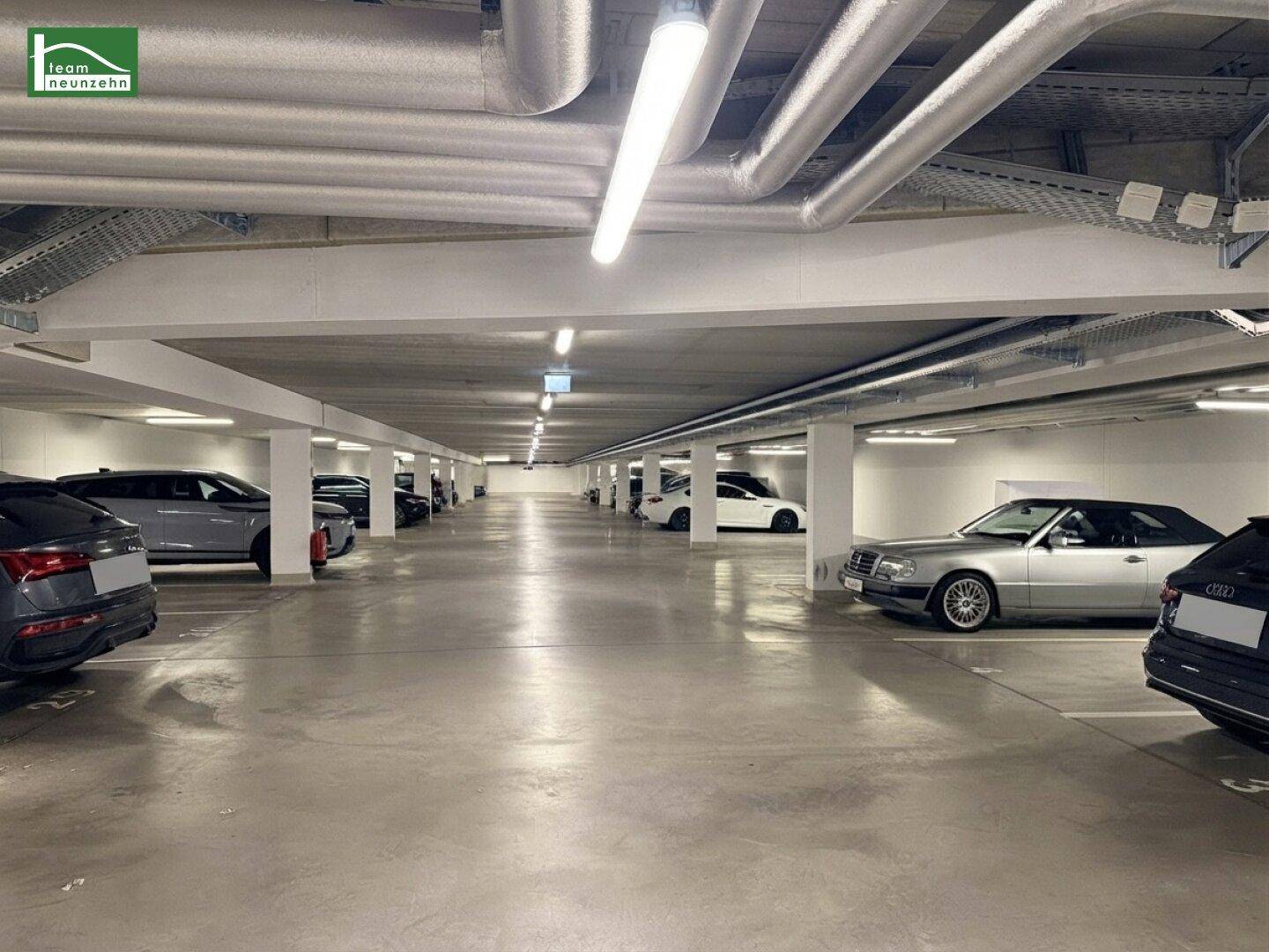 Tiefgarage mit zahlreichen Stellplätzen und Betonkonstruktion im Untergeschoss des Gebäudes.