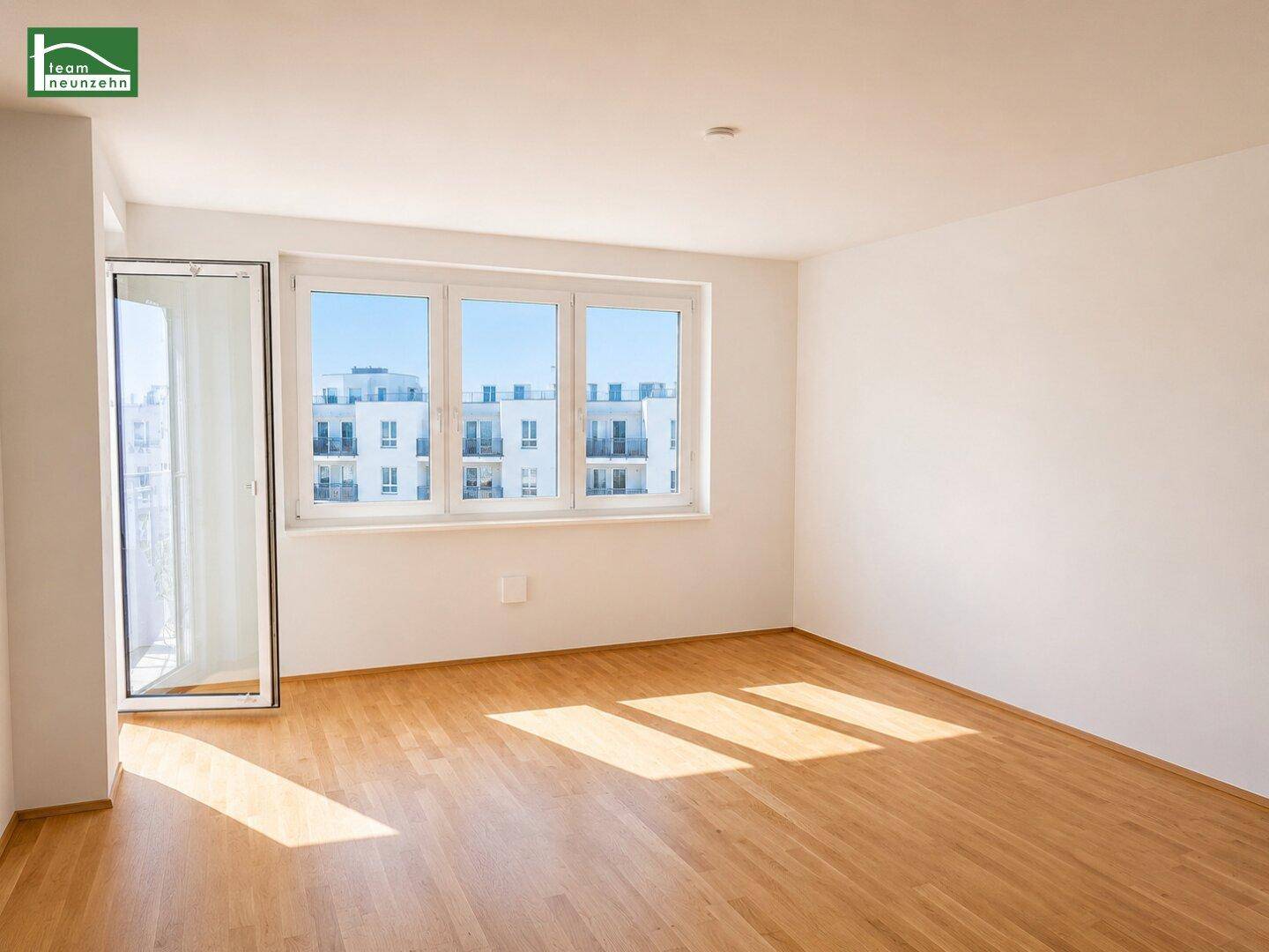 Lichtdurchfluteter Raum mit Holzboden und großen Fenstern, ideal für einen Wohnbereich.