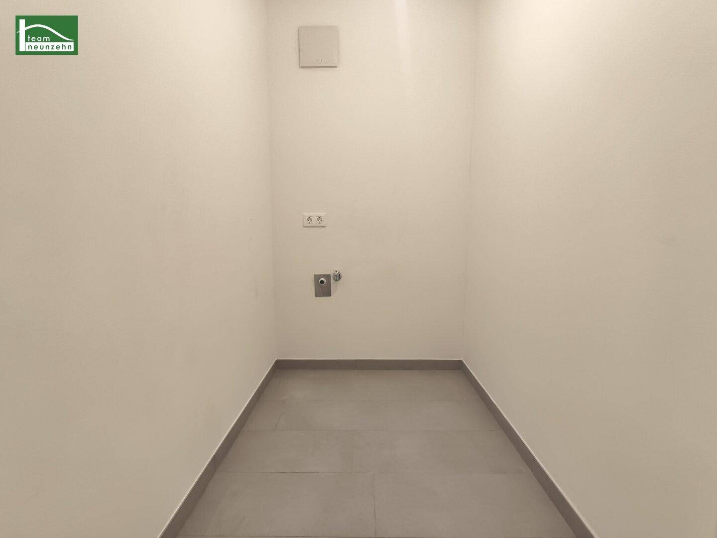 Praktischer Hauswirtschaftsraum mit Fliesenboden und Anschlüssen für Waschmaschine.