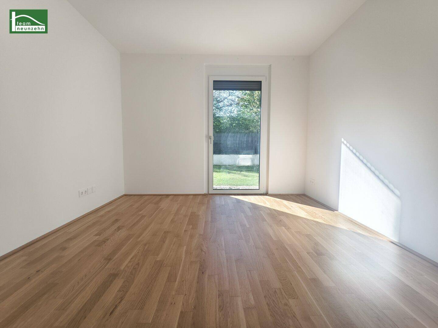 Helles Schlafzimmer mit Holzboden und Zugang zum Garten, ideal für erholsame Nächte.