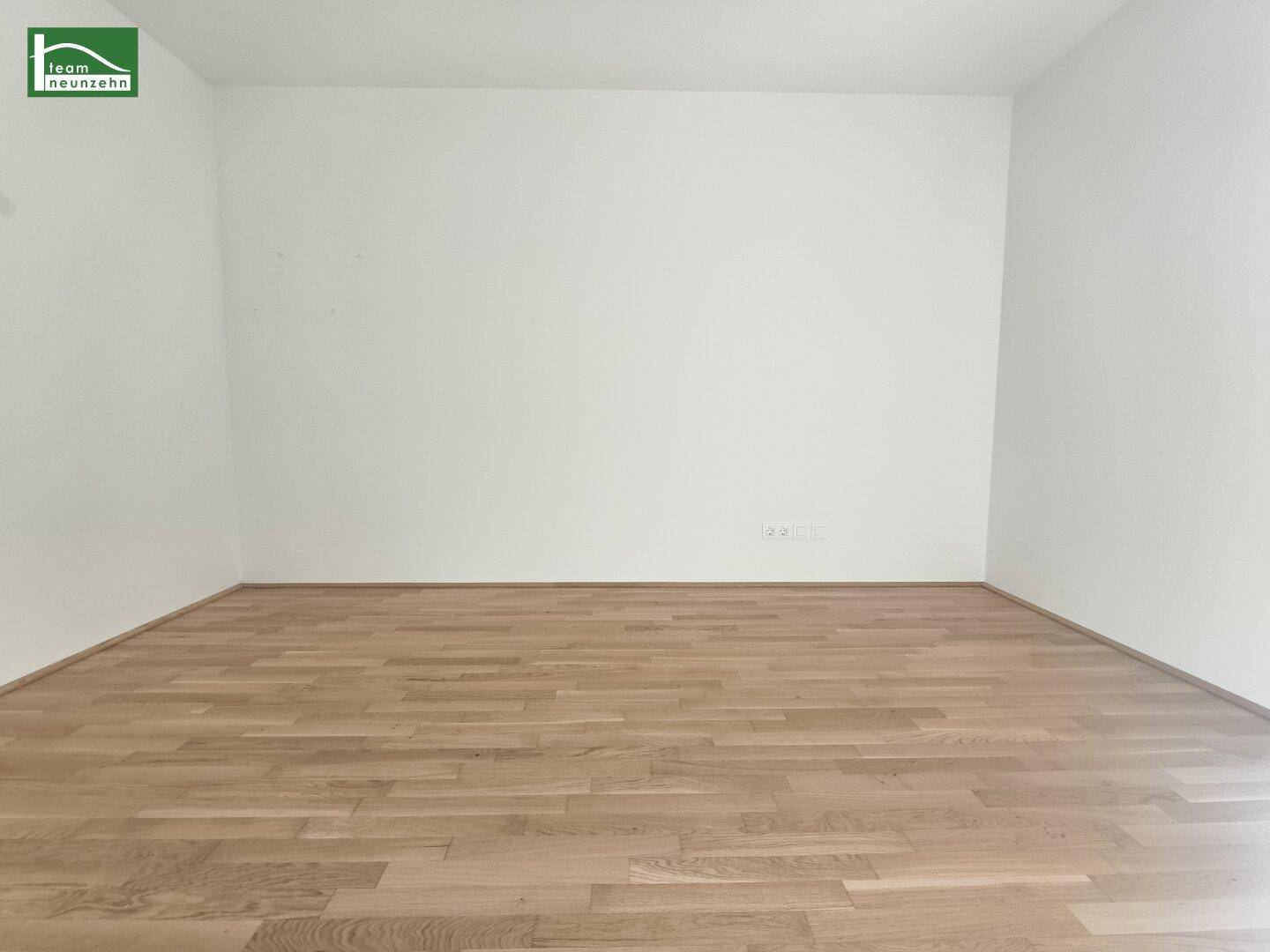 Unmöblierter Raum mit hellem Holzboden und weißen Wänden, vielseitig nutzbar.