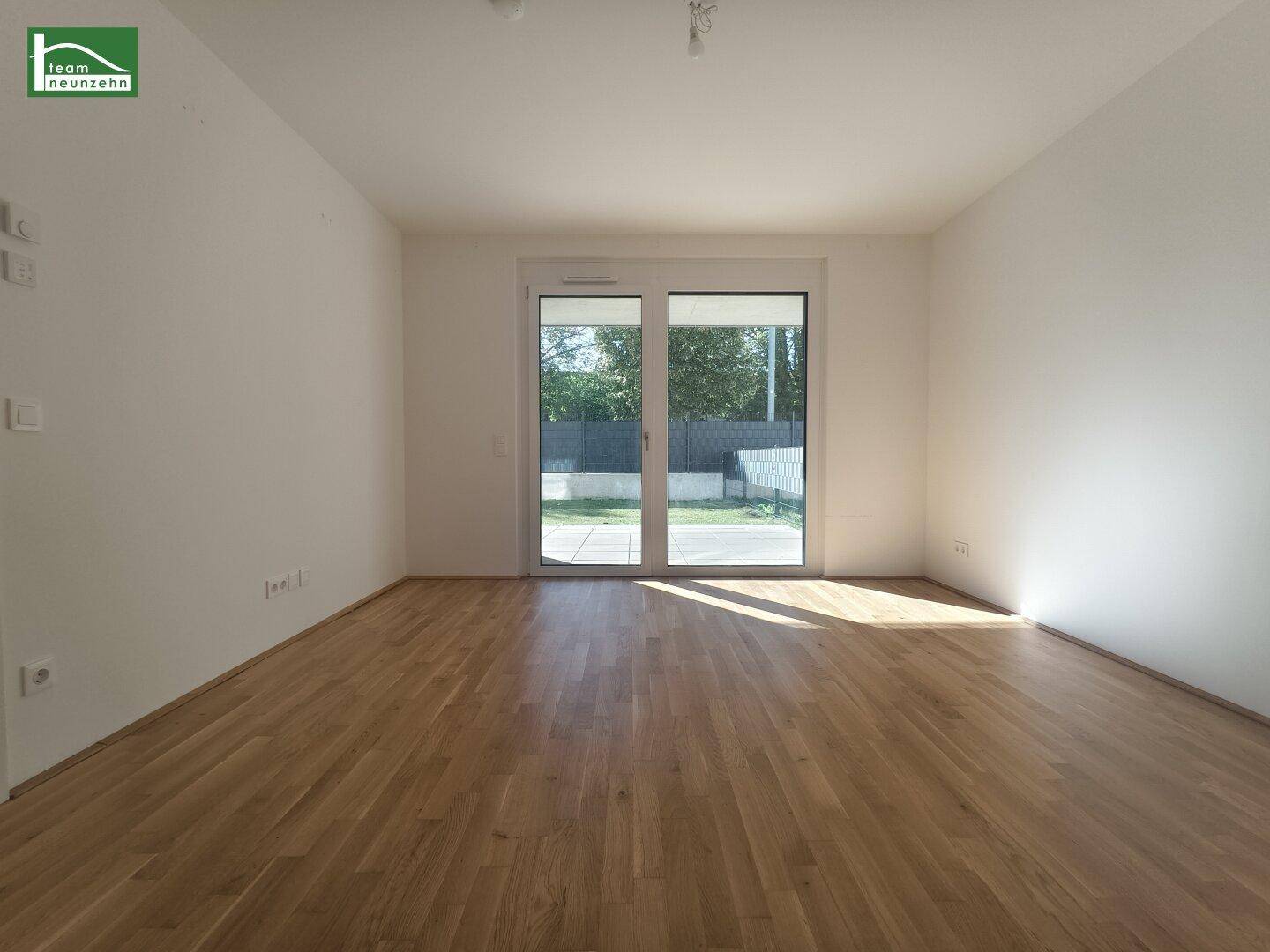 Lichtdurchfluteter Raum mit Holzboden und direktem Zugang zum Außenbereich.