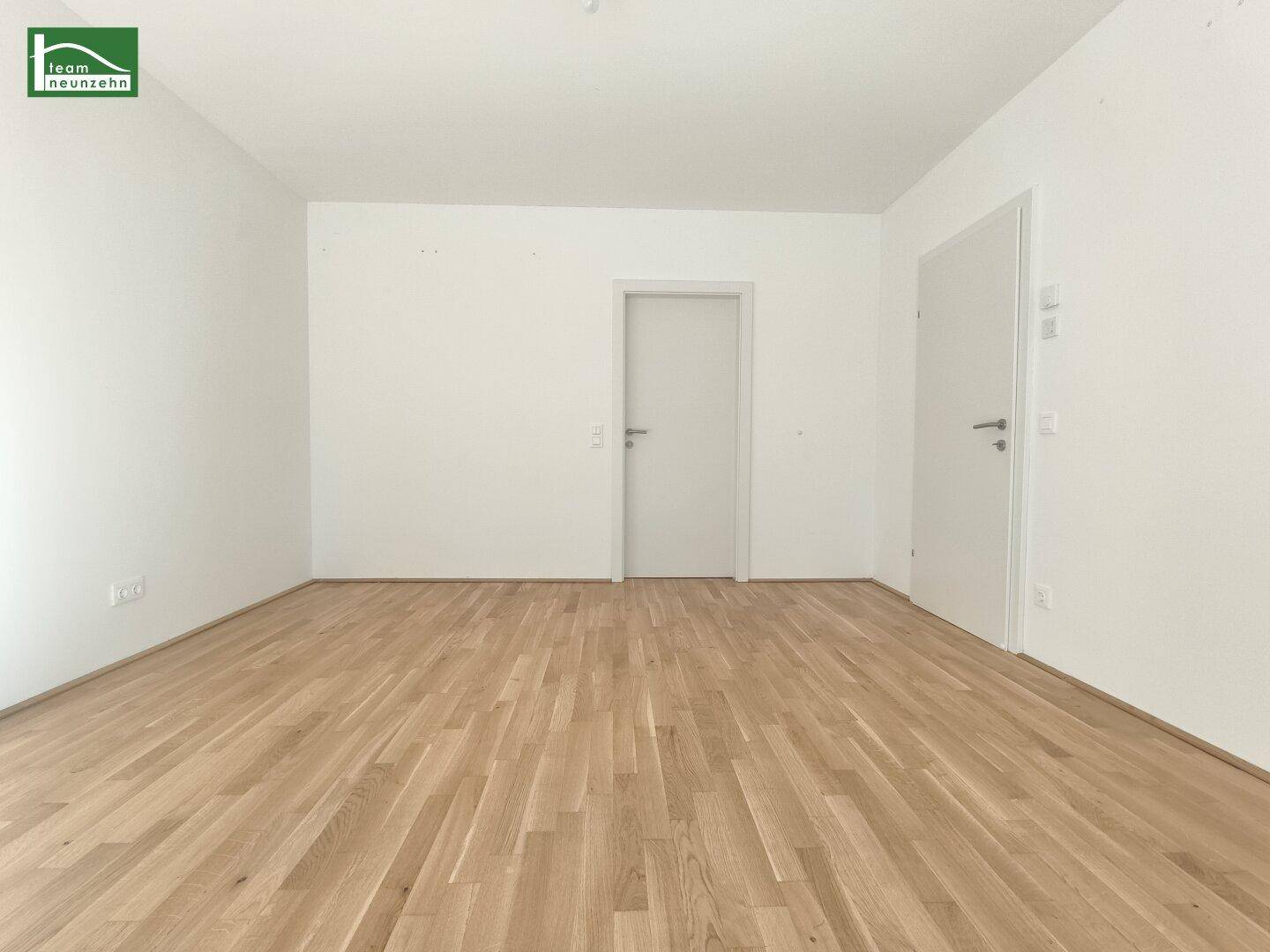 Leerer Raum mit Holzboden und zwei Türen, ideal für verschiedene Nutzungskonzepte.
