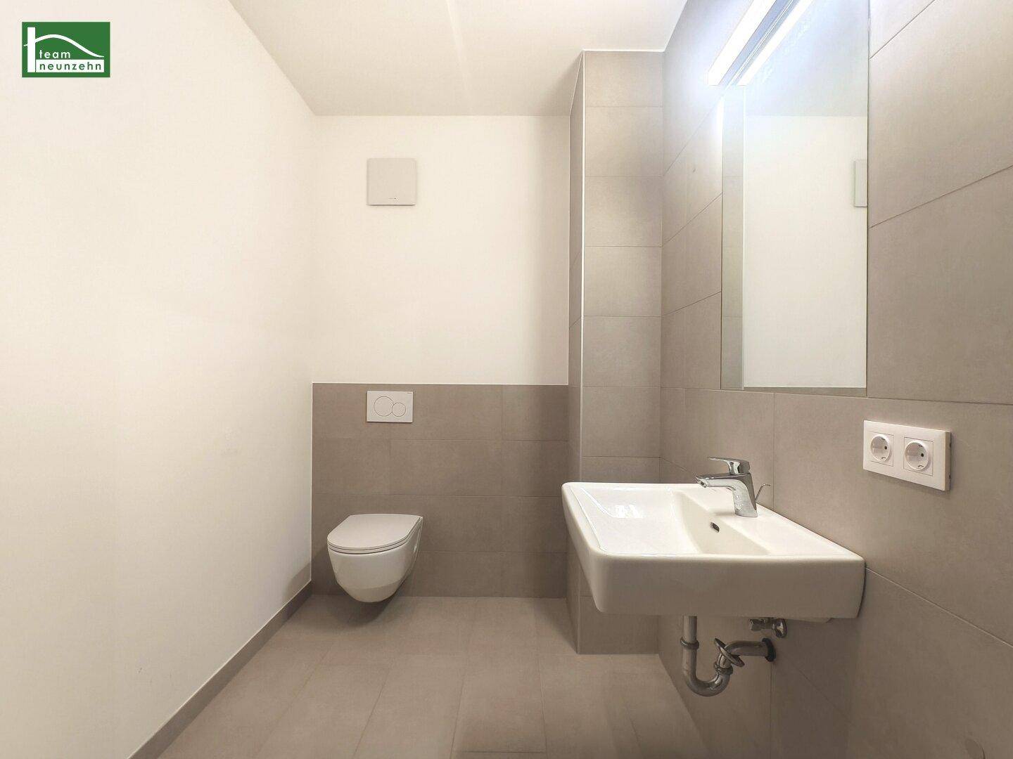 Modernes Gäste-WC mit wandhängender Toilette und stilvollem Waschtisch.