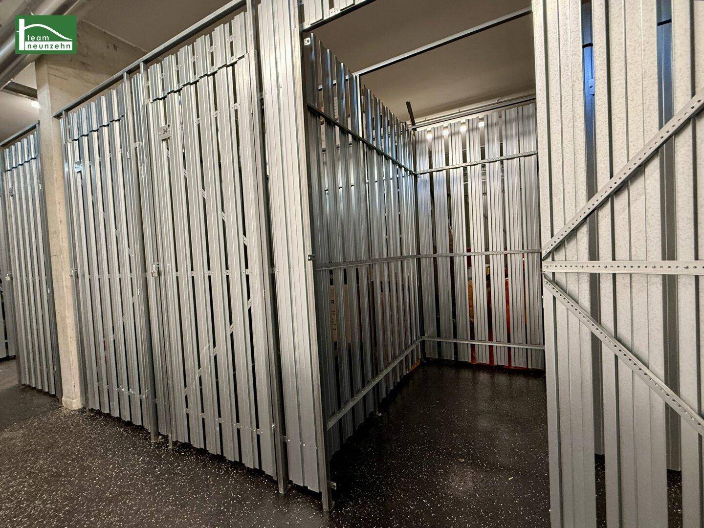 Mehrere Abstellräume in einem gemeinsamen Kellerbereich mit Metallabtrennungen.