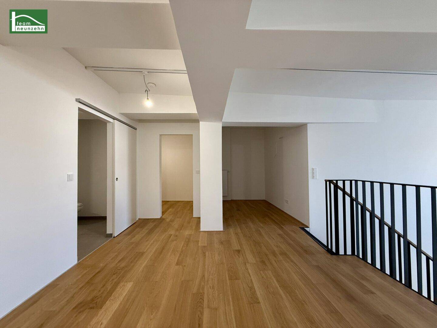 Offener Galeriebereich mit Holzboden und Blick auf die angrenzenden Räume.