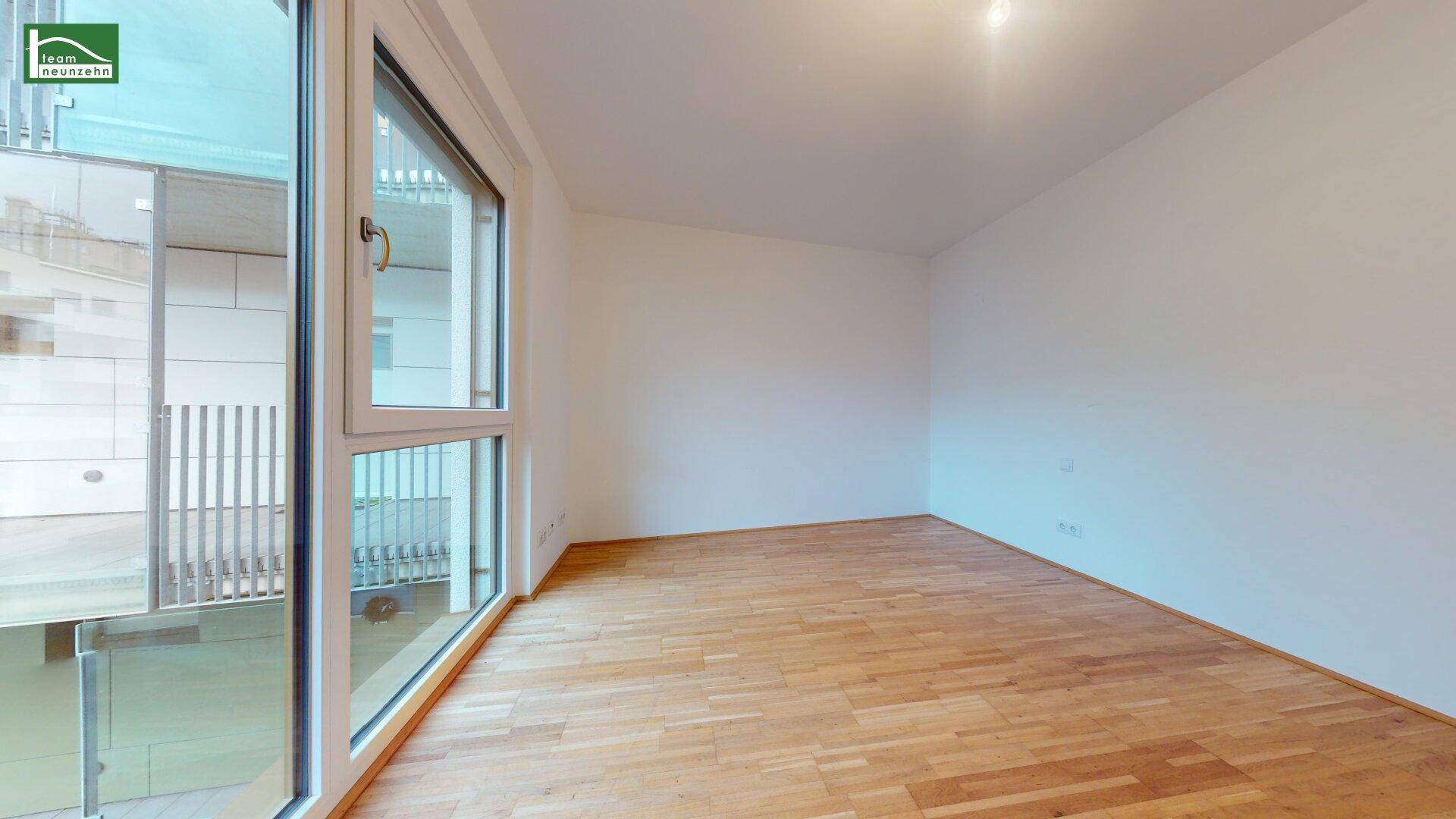 Geräumiges Schlafzimmer mit Holzboden und bodentiefen Fenstern, die einen Blick nach draußen ermöglichen.