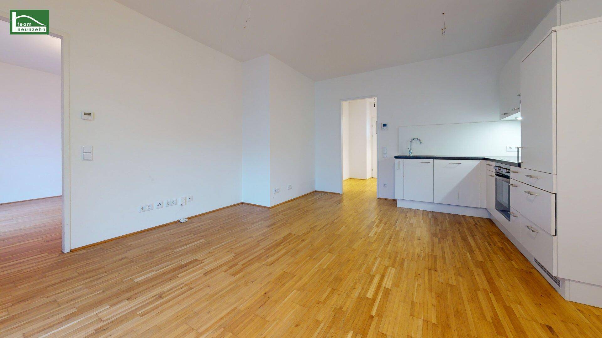 Heller Wohnbereich mit offener Küche und Holzboden, ideal für modernes Wohnen.