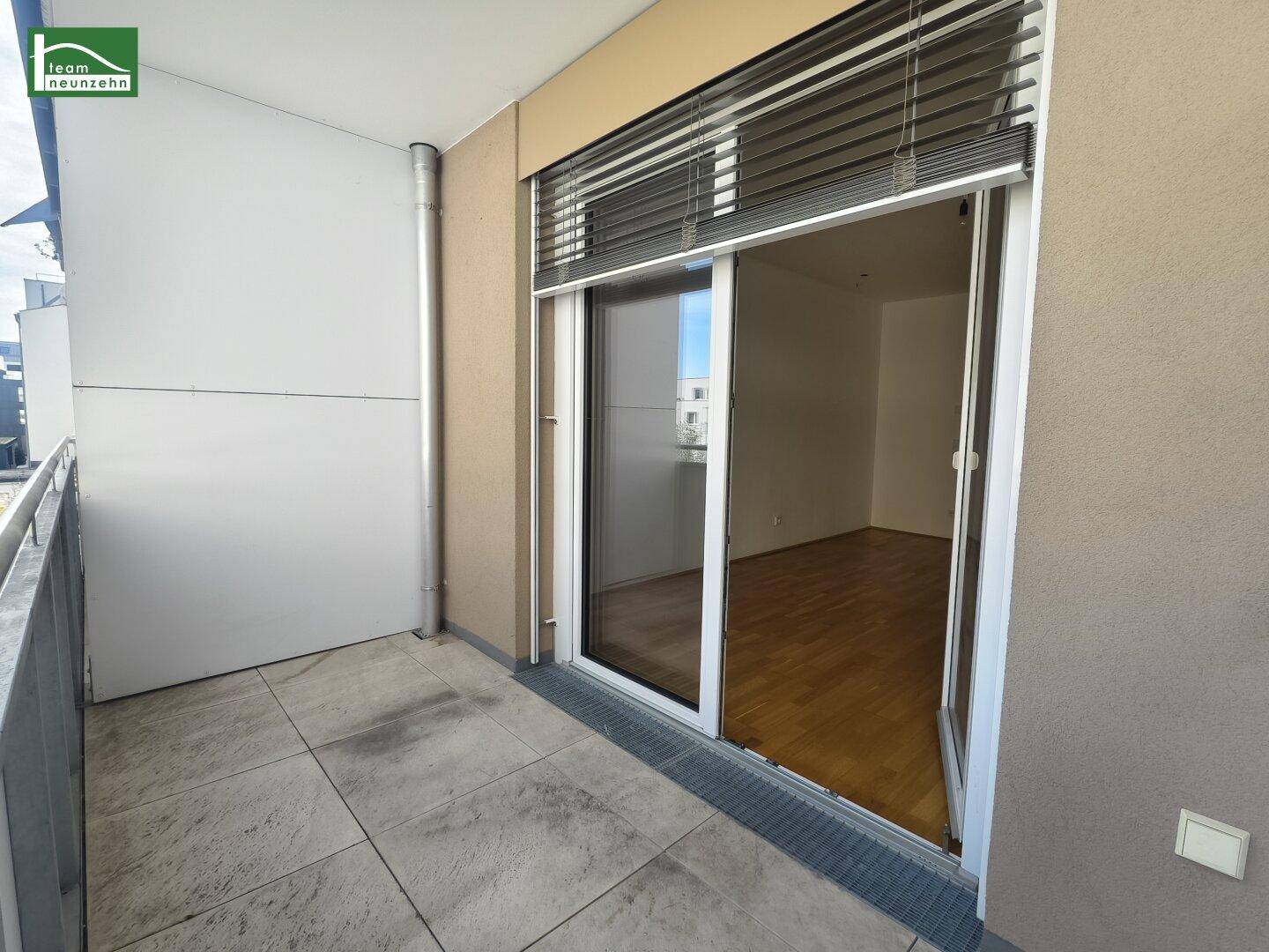 Geräumiger Balkon mit Fliesenboden und Blick auf die Umgebung, zugänglich vom Innenbereich.