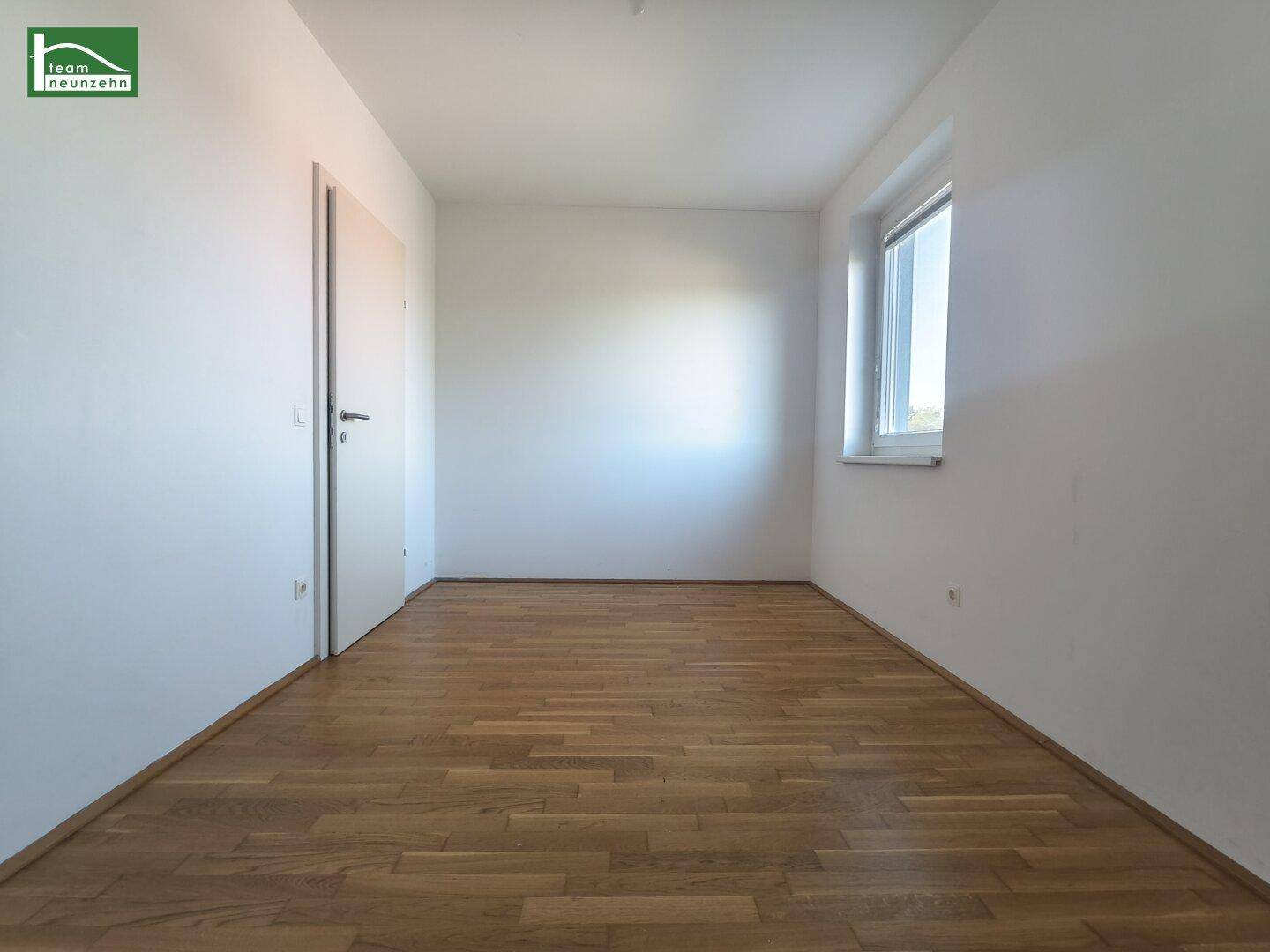 Geräumiges Zimmer mit Parkettboden und weiß gestrichenen Wänden, vielseitig nutzbar.