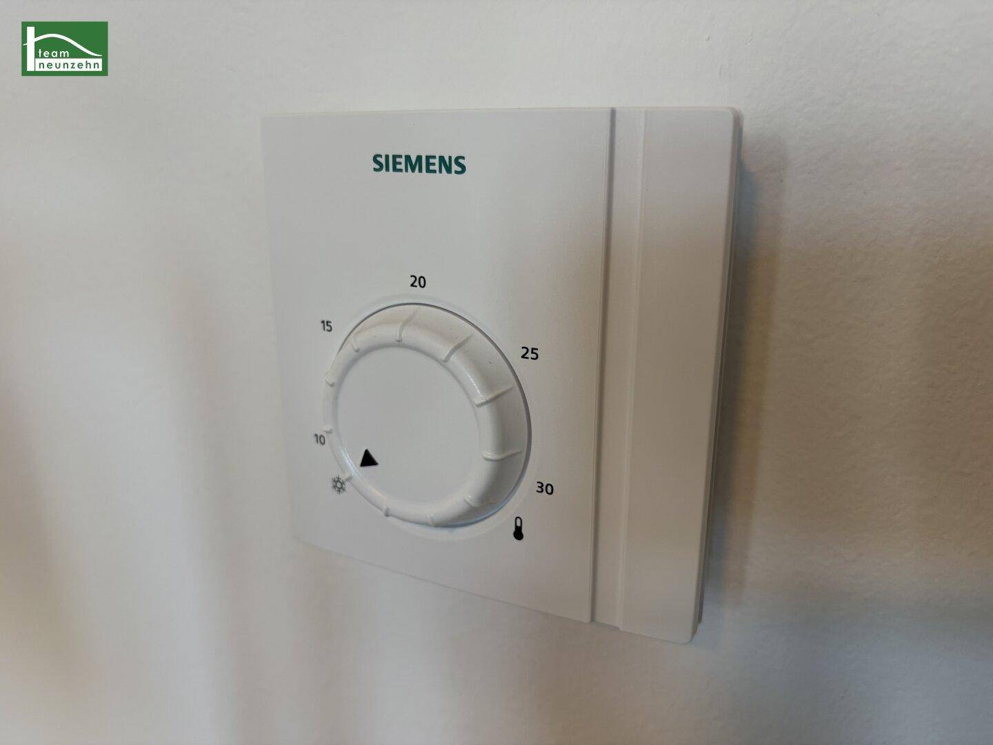 Siemens-Thermostat zur Temperaturregelung an einer weißen Wand, einfach und funktional.