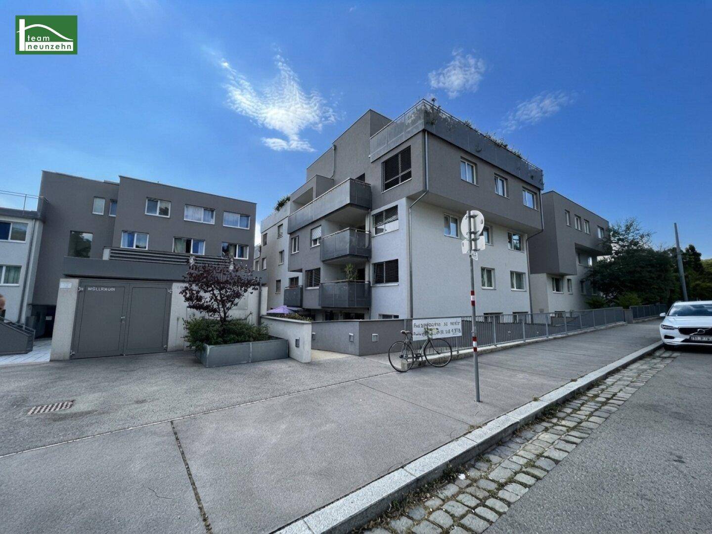 Moderne Wohnanlage mit mehreren Balkonen und zeitgenössischer Architektur an einer ruhigen Straße.