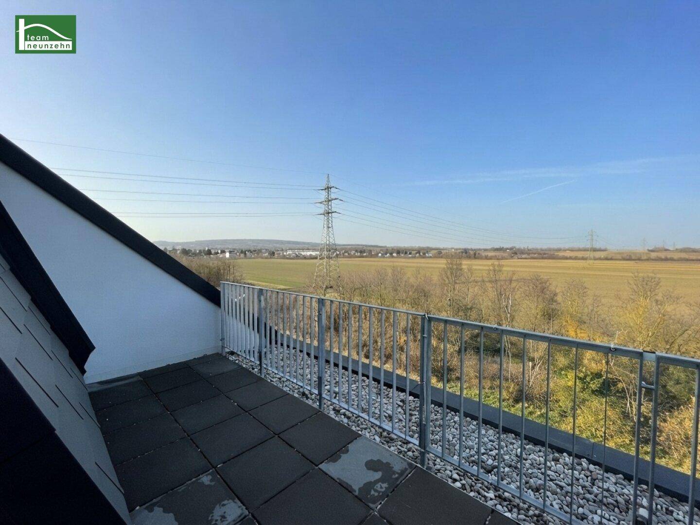 Balkon mit weitem Blick über grüne Felder und die ländliche Umgebung.