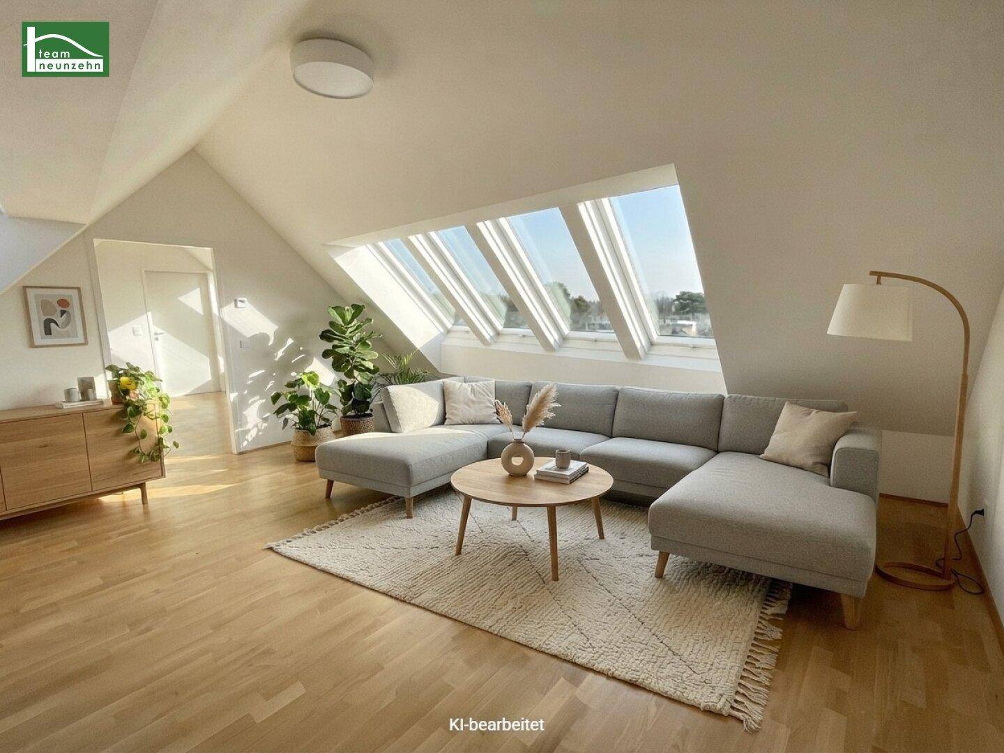 Modern eingerichtetes Wohnzimmer im Dachgeschoss mit bequemer Couch und viel Tageslicht.