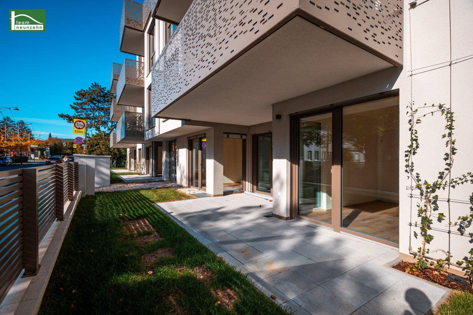 Moderne Erdgeschossfassade mit Terrassen und gepflegten Grünflächen, ideal für Erholung.