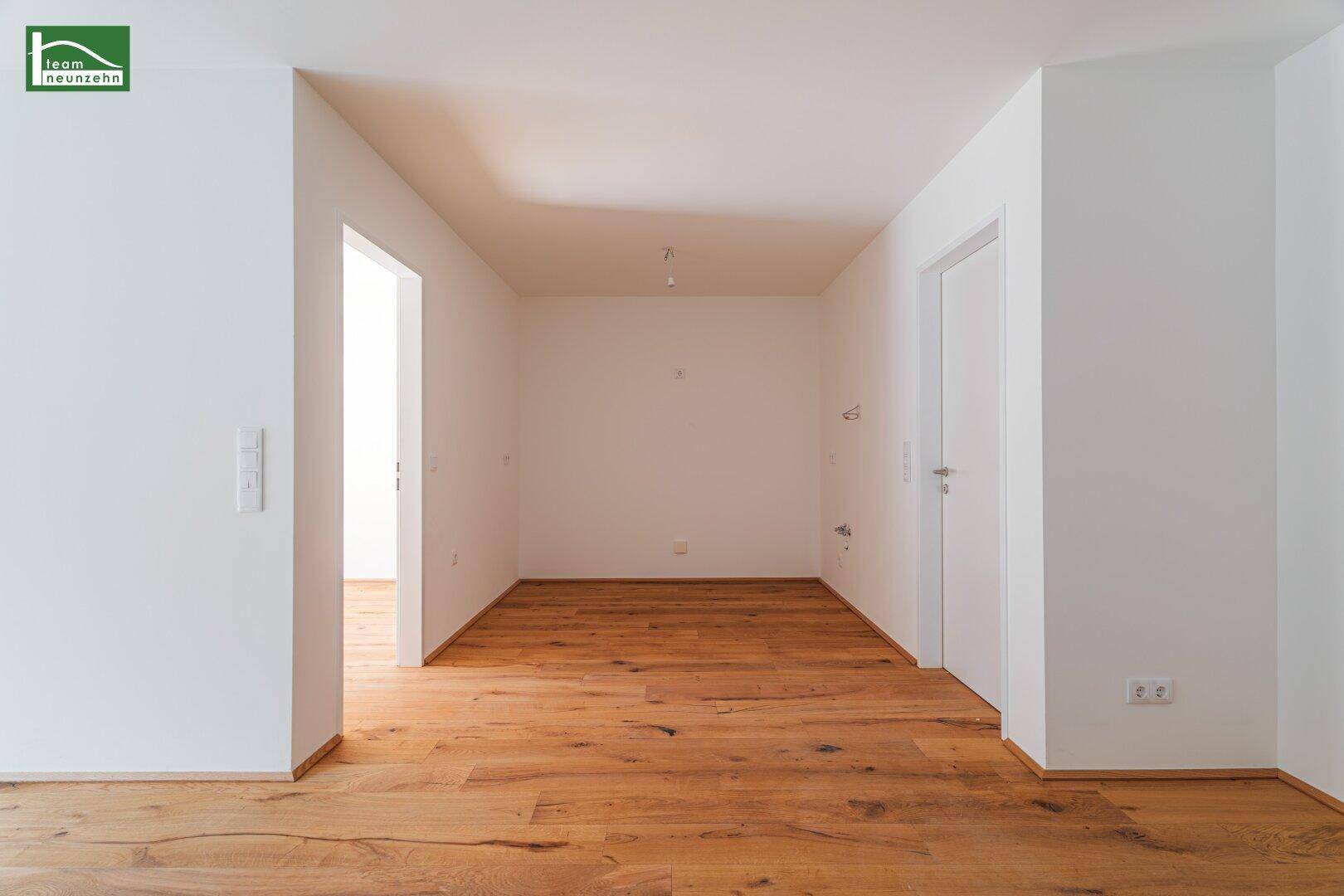 Geräumiger, unmöblierter Raum mit Holzboden und weiß gestrichenen Wänden.