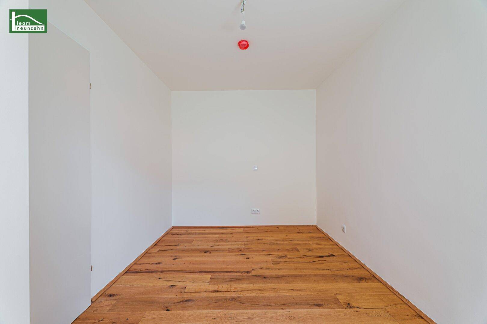 Unmöblierter Raum mit Holzboden und weißen Wänden, ideal für individuelle Gestaltung.