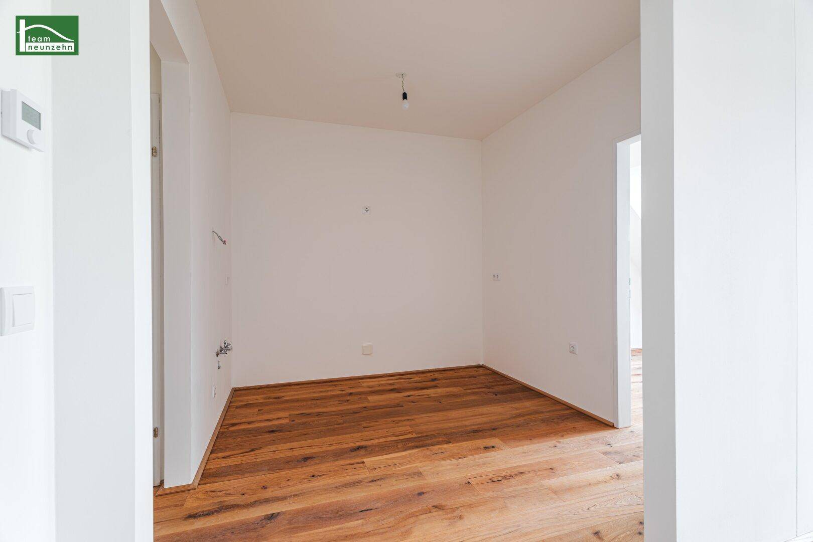 Kleiner, heller Raum mit Holzboden und weiß gestrichenen Wänden, vielseitig nutzbar.