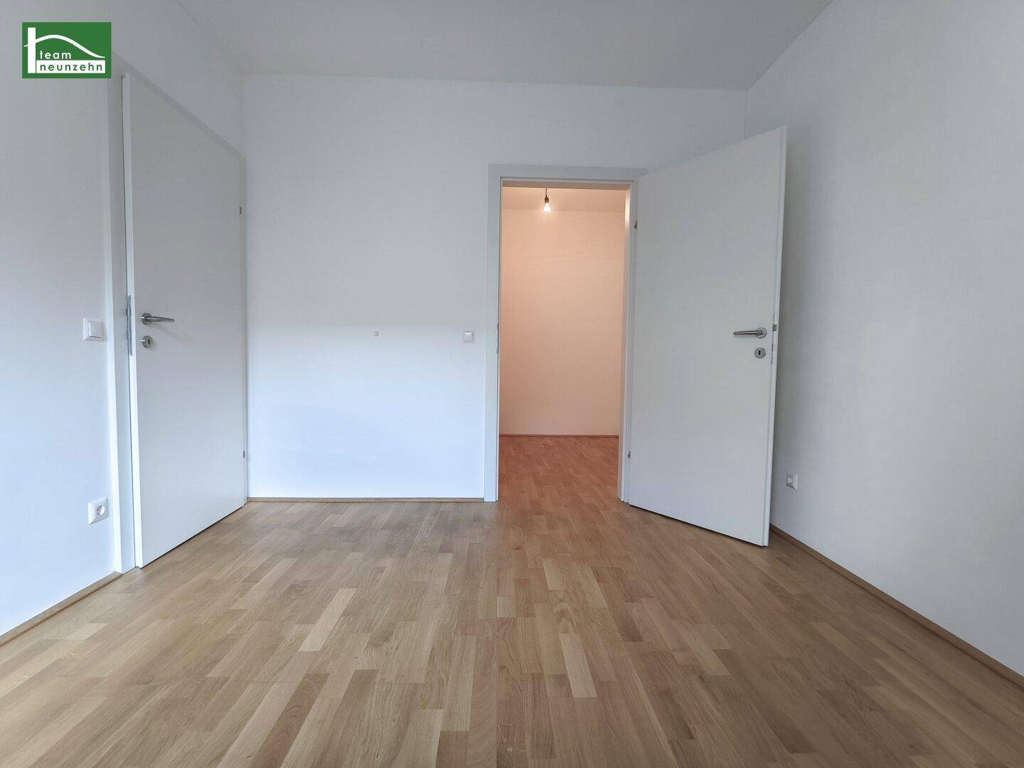 Leerer Raum mit Parkettboden und zwei weißen Türen, vielseitig nutzbar in der Wohnung.