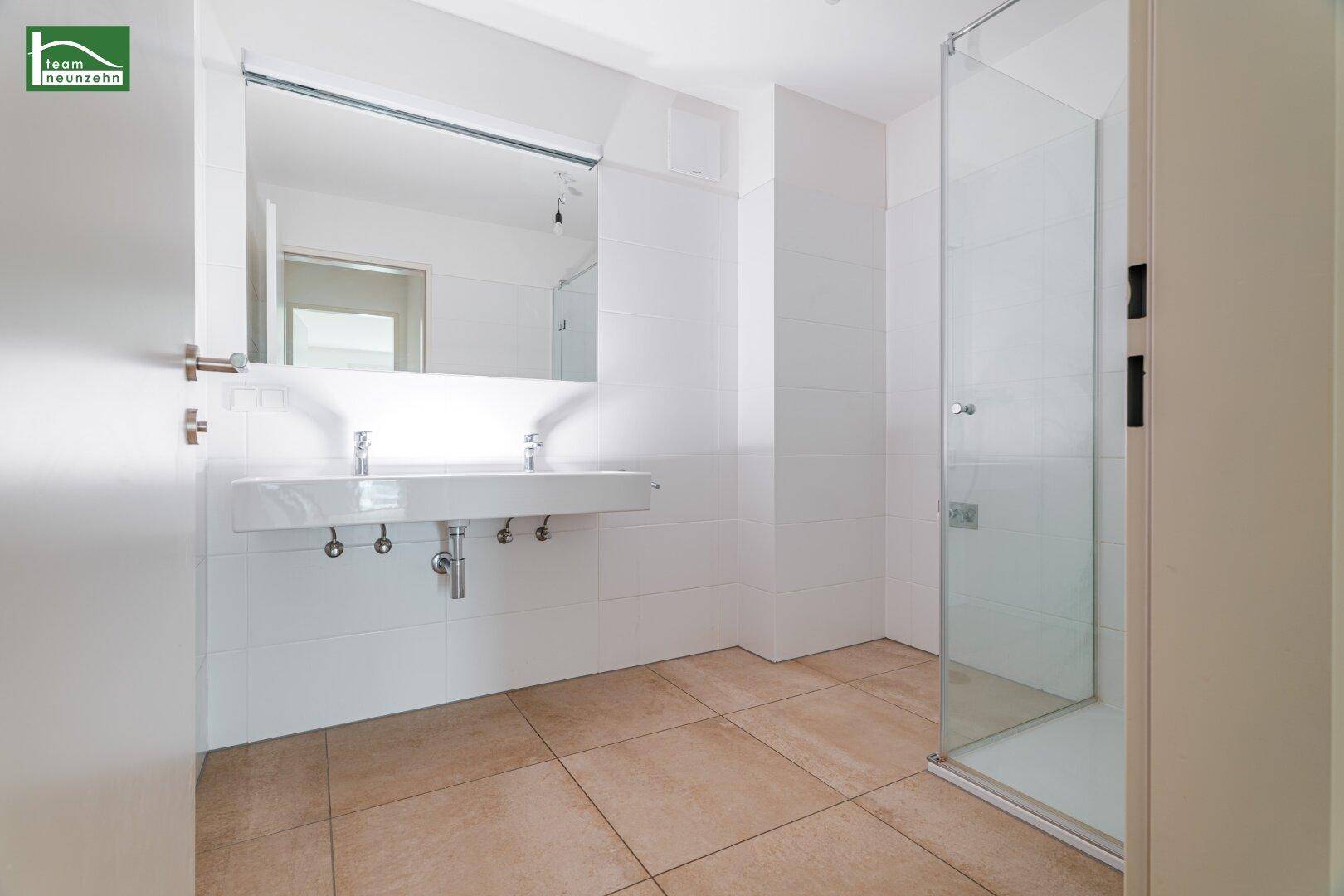 Modernes Badezimmer mit Doppelwaschbecken, großem Spiegel und begehbarer Dusche.