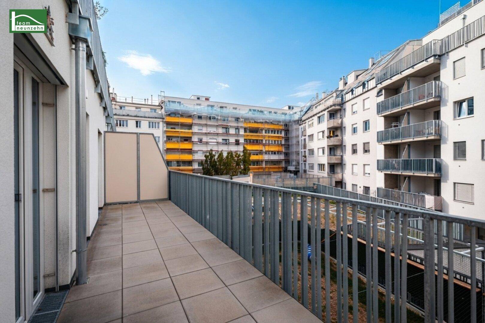 Große Dachterrasse mit Metallgeländer und Blick auf umliegende Gebäude.