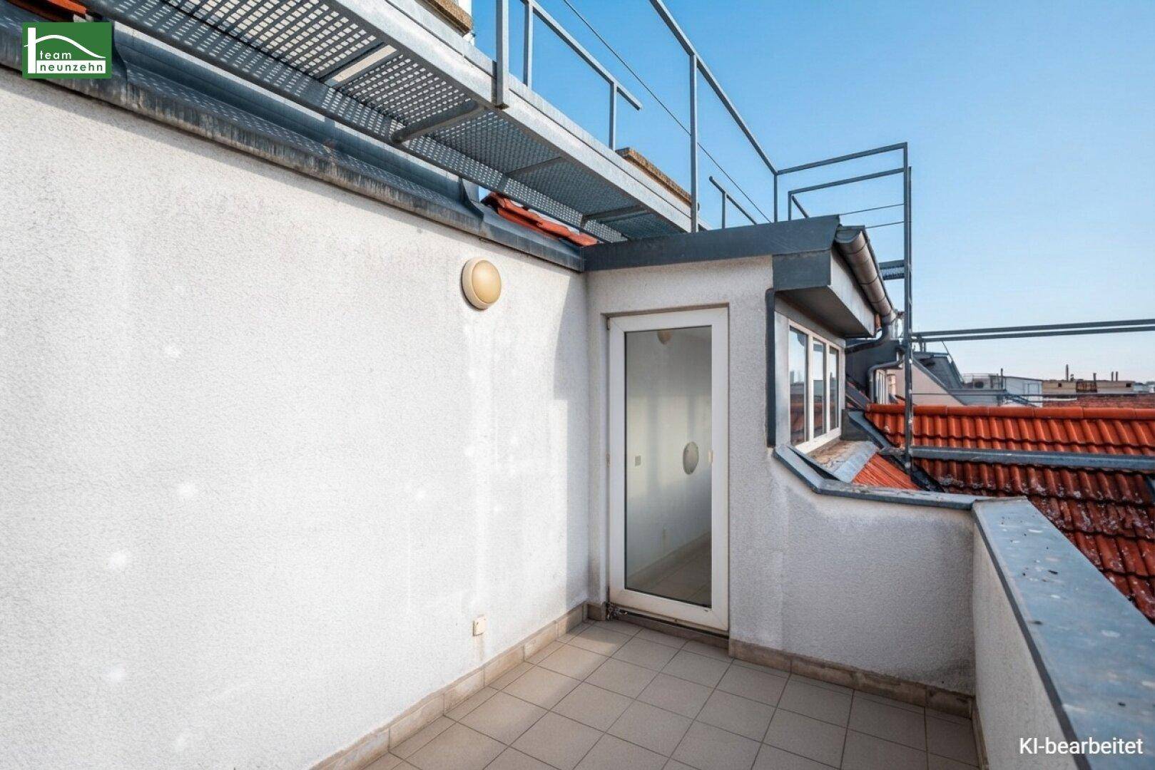 Dachbalkon mit Zugang zum Innenbereich und Blick auf die umliegenden Dächer.