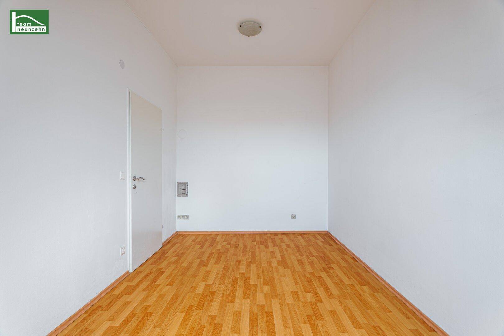 Leerer Raum mit Holzboden und weißen Wänden, bereit zur individuellen Gestaltung.