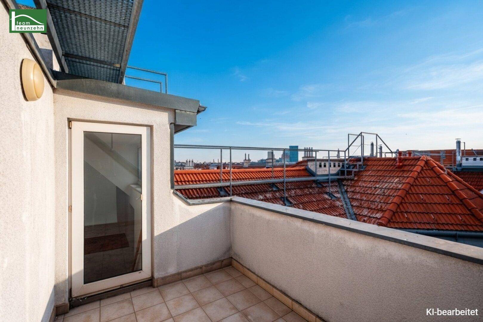 Sonniger Außenbereich auf der Dachterrasse mit Blick über die umliegenden Dächer der Stadt.