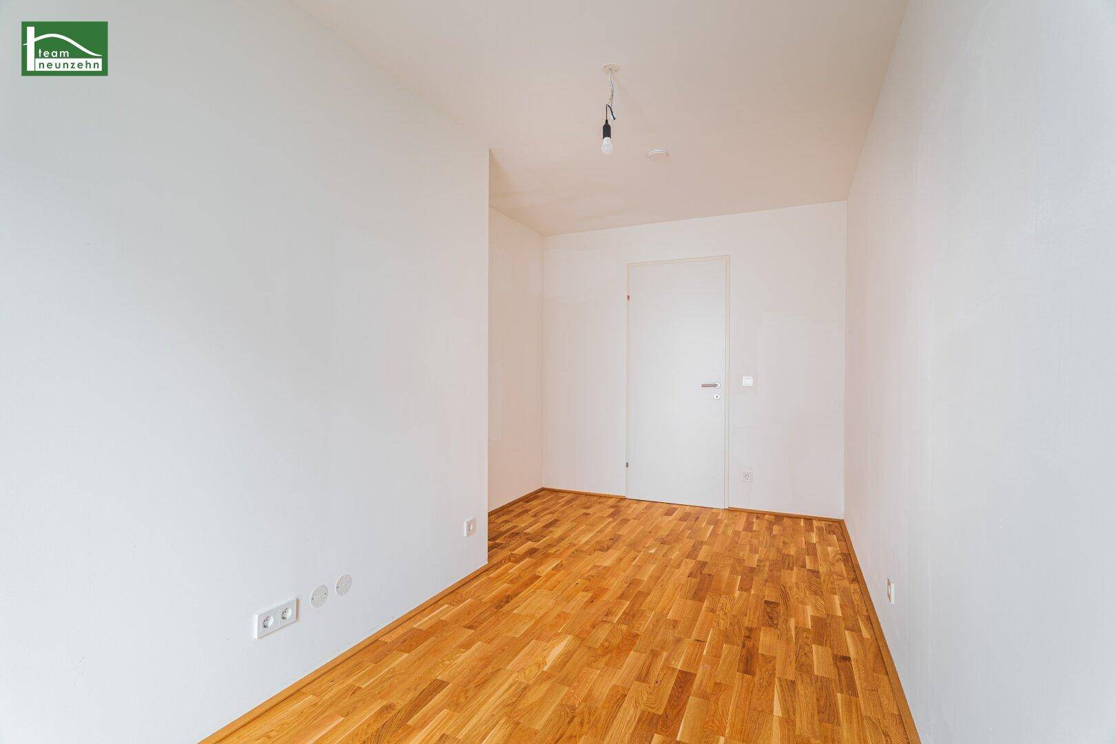 Heller Raum mit Parkettboden und weißen Wänden, bereit für individuelle Gestaltung und Nutzung.