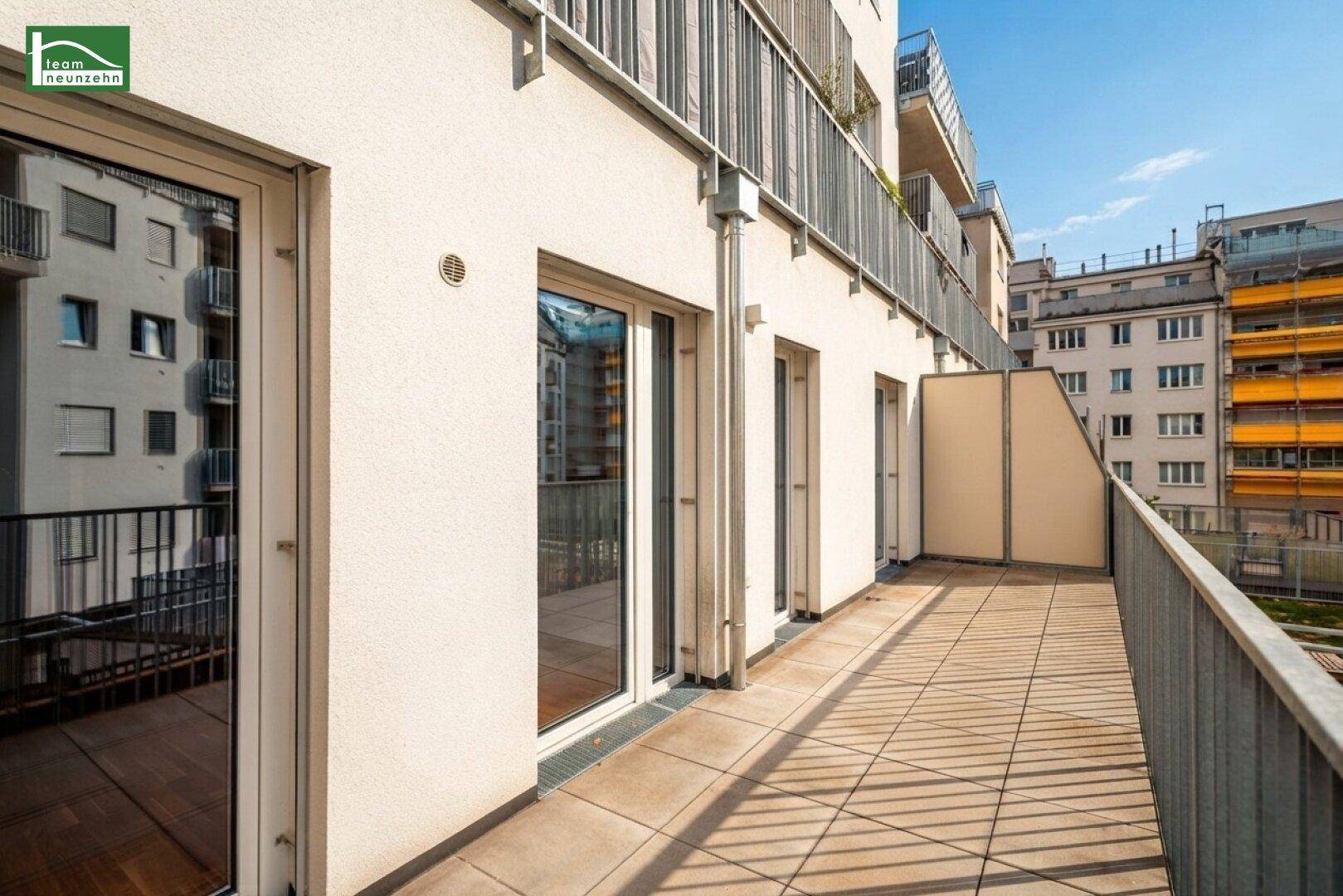 Breite Terrasse mit Fliesenboden und mehreren Zugängen von den Innenräumen des Gebäudes.