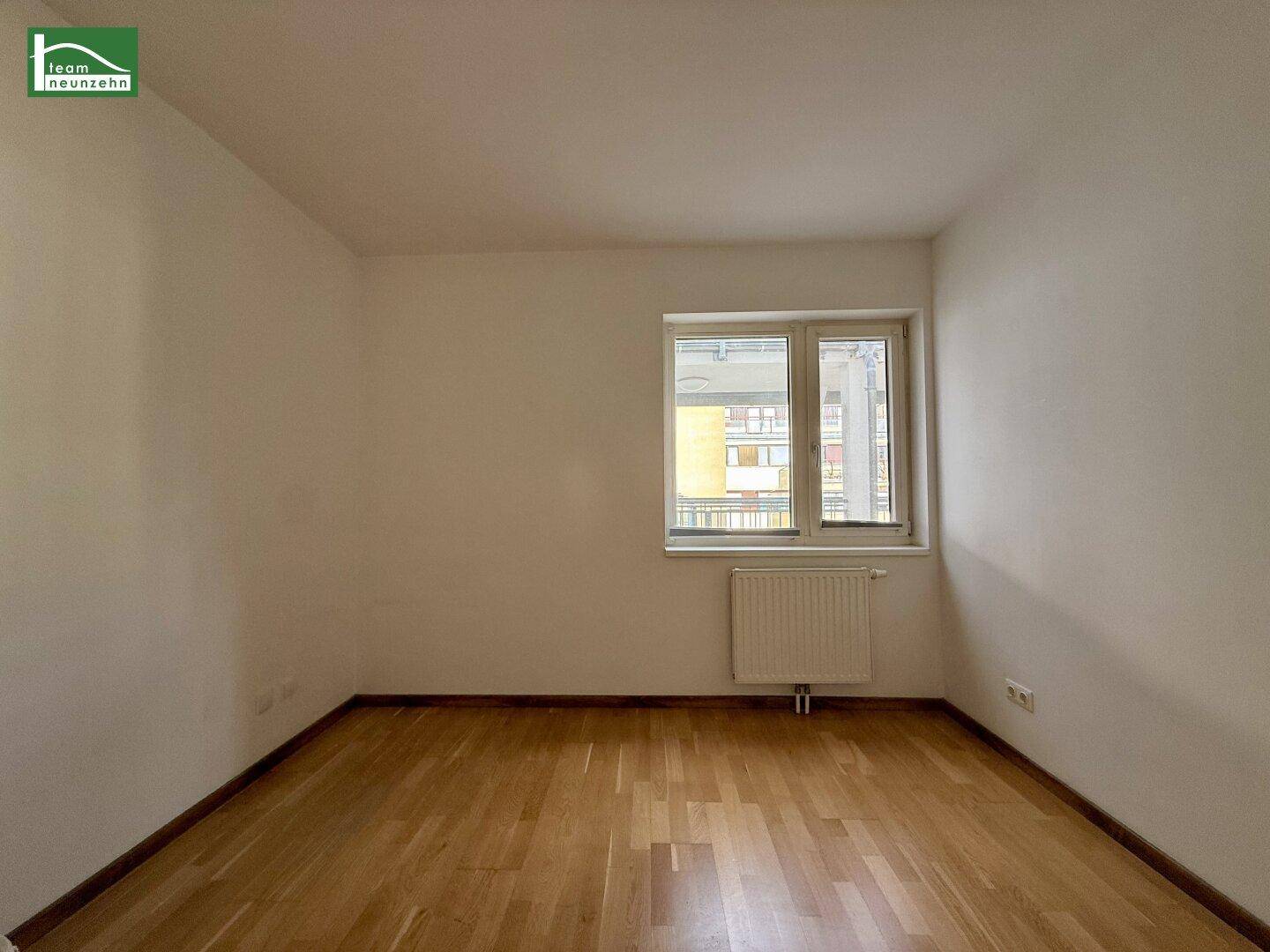Leeres Zimmer mit Parkettboden und Fenster, vielseitig nutzbar als Schlaf- oder Kinderzimmer.