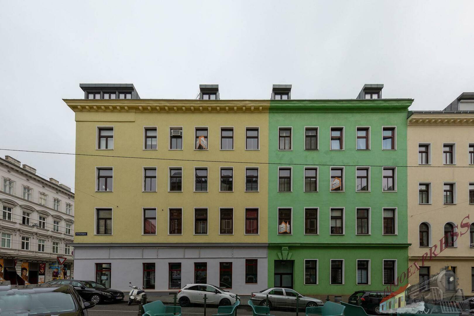 Fassade eines Gebäudes mit auffälliger gelb-grüner Farbgebung und vielen Fenstern.