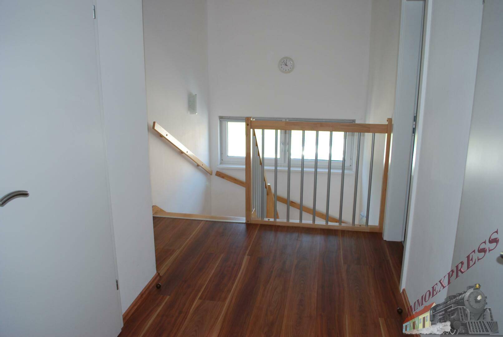 Heller Flur im Obergeschoss mit Holzboden und Fenster.