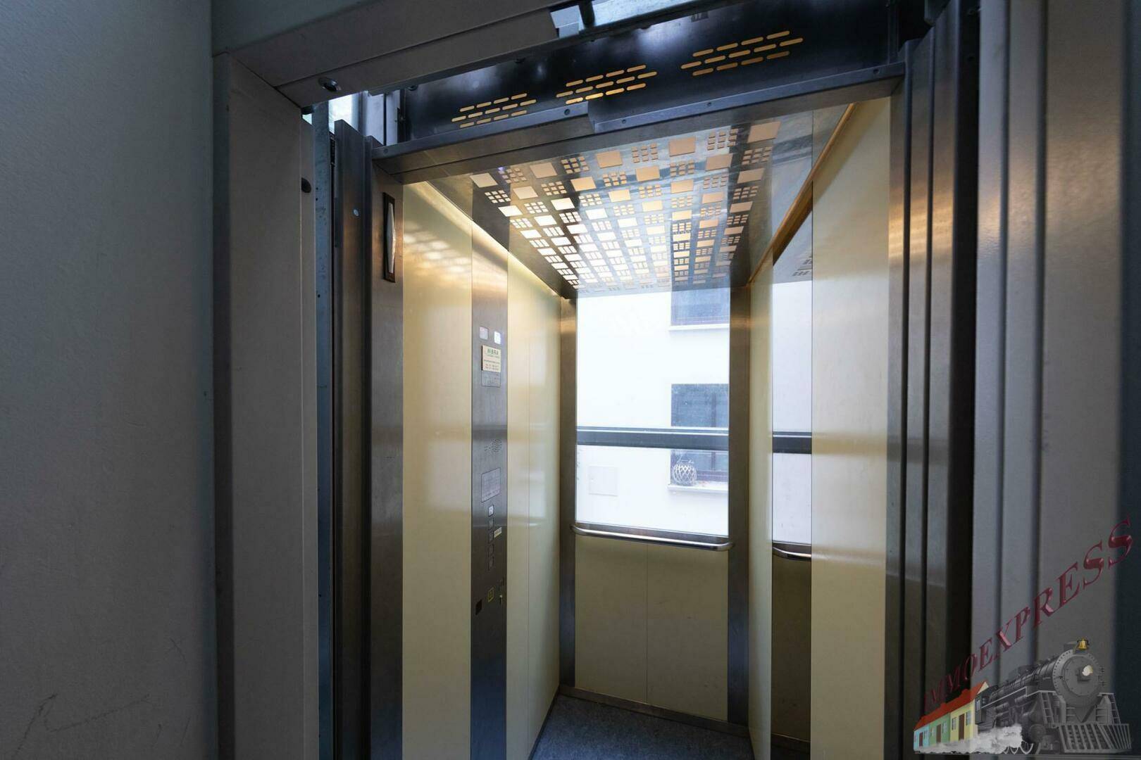 Moderner Aufzug mit Glaswänden und Blick nach außen im Gebäudeinneren.
